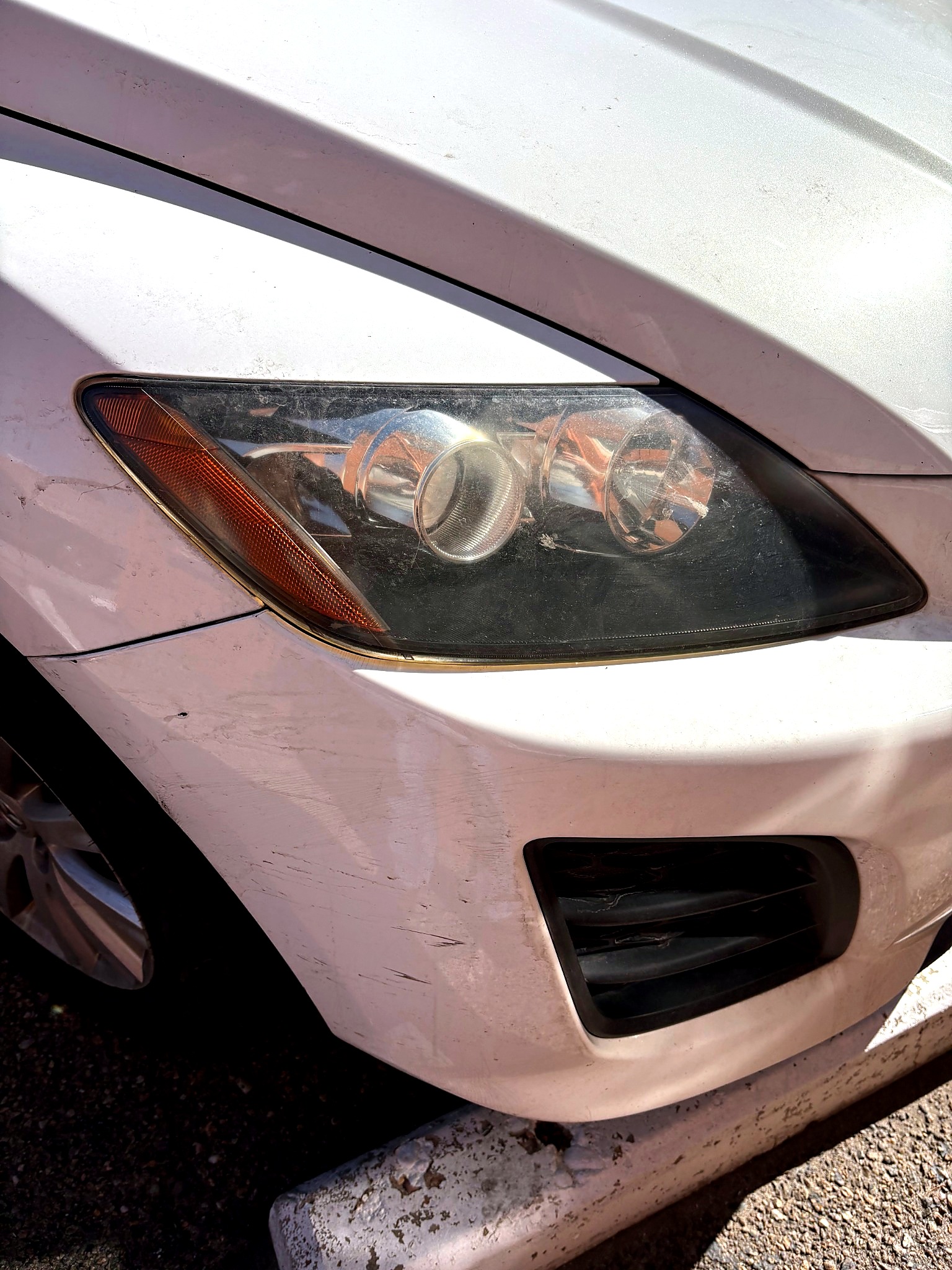 Cloudy white vehicle headlight before restoration