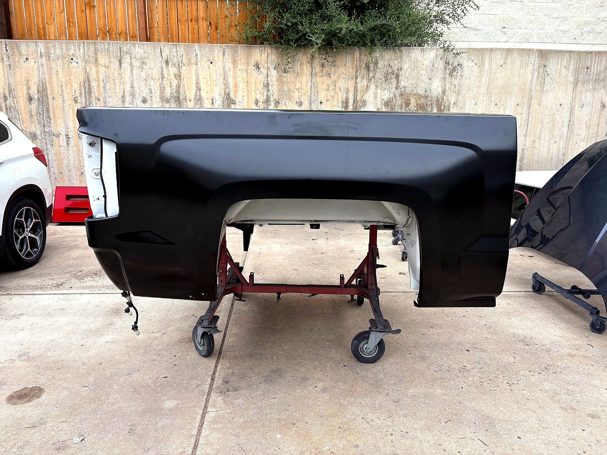 Black primed truck bed panel on shop stand