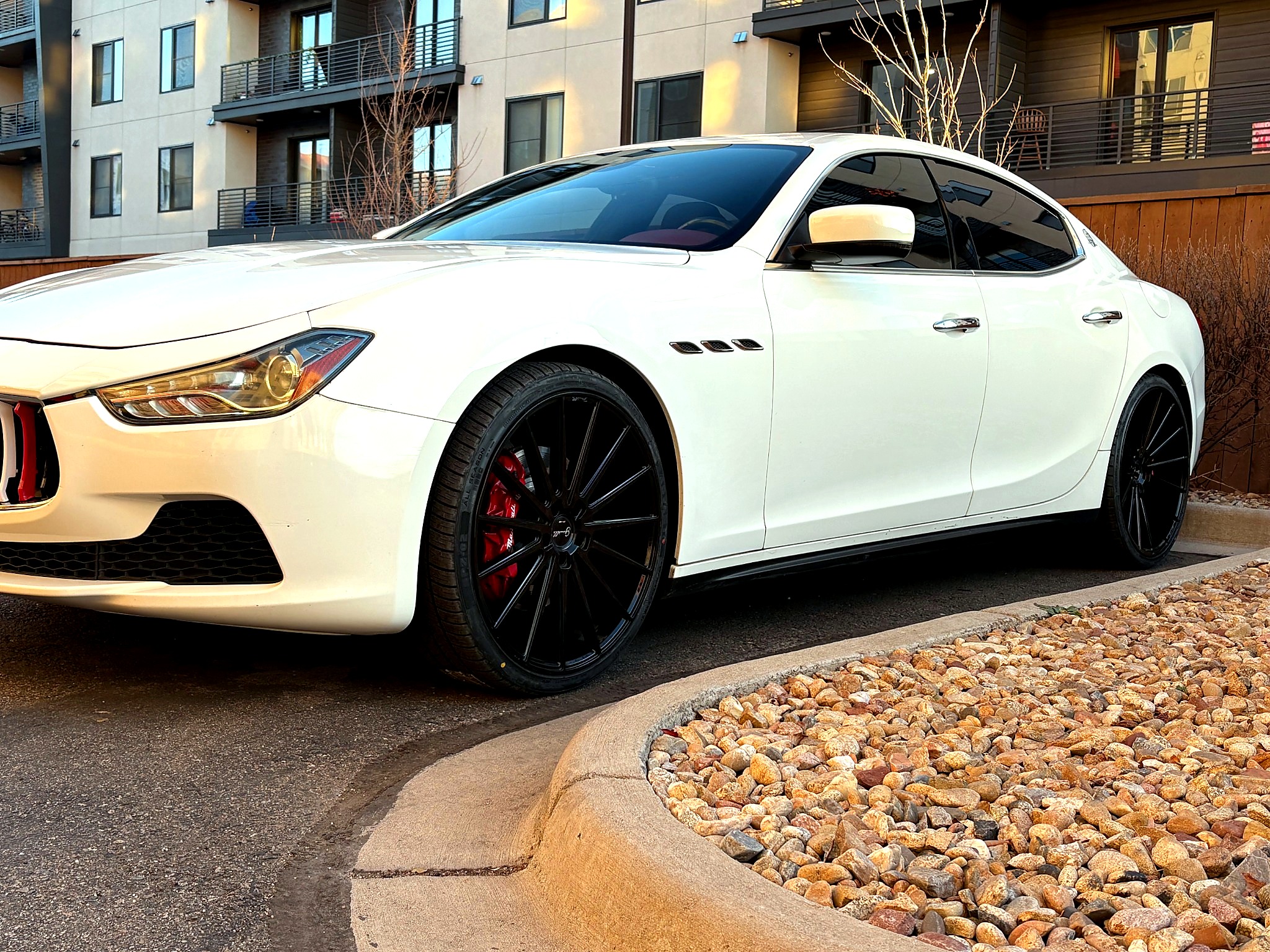 White Maserati luxury sedan front-side exterior at sunset