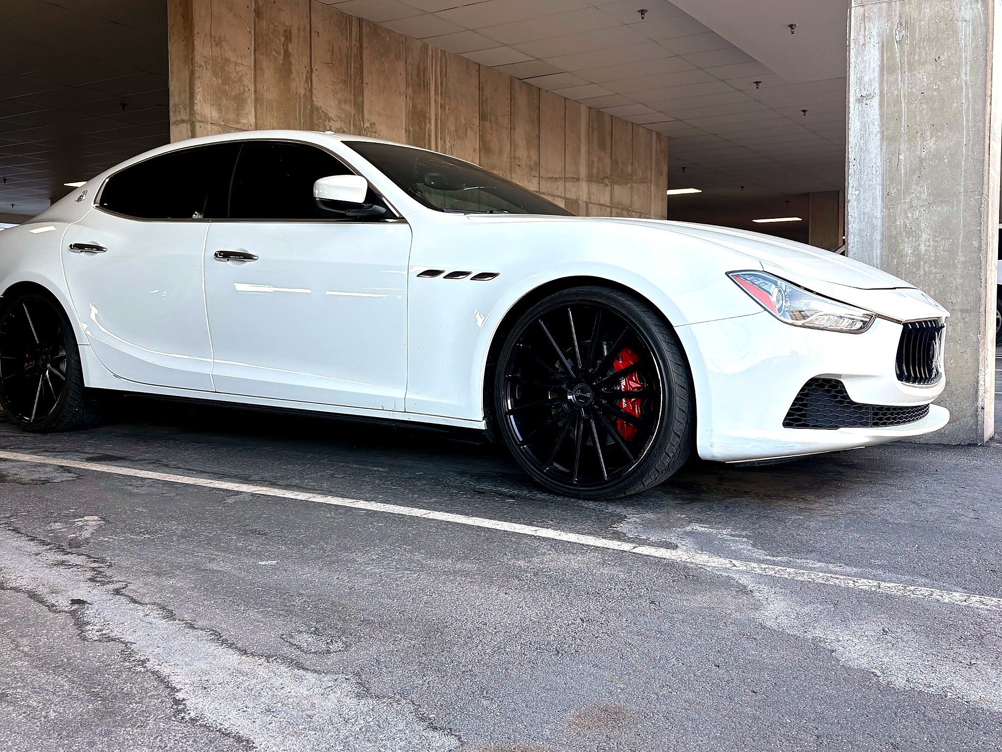 White Maserati luxury sedan side profile in garage setting