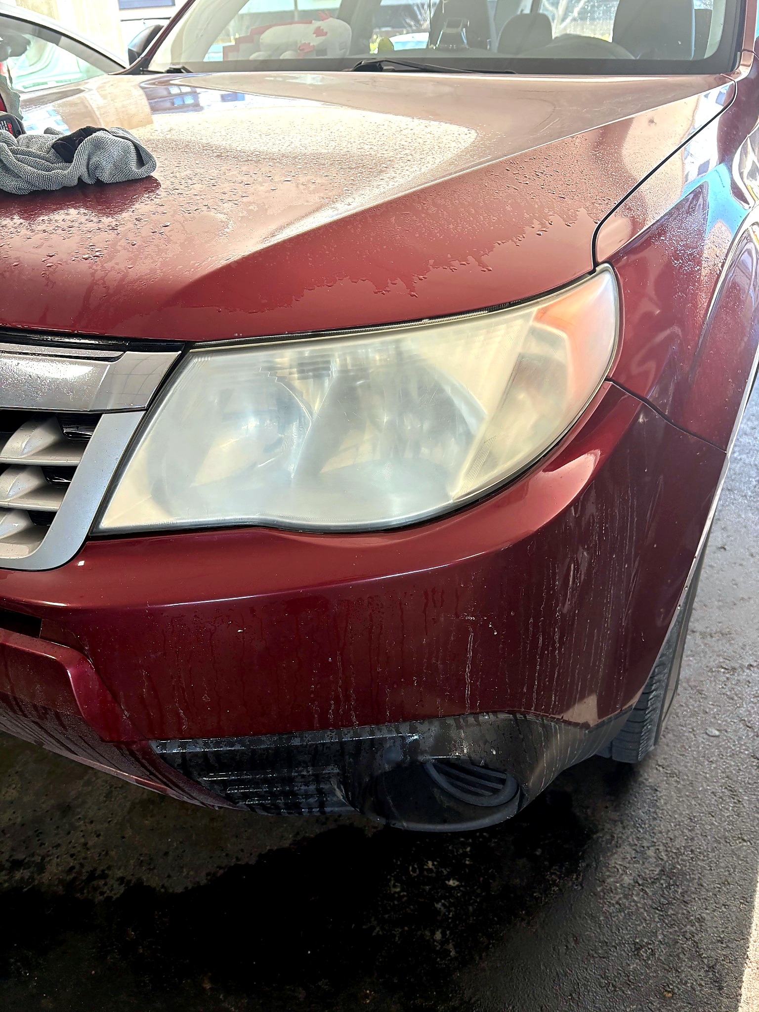 Cloudy red vehicle headlight before restoration