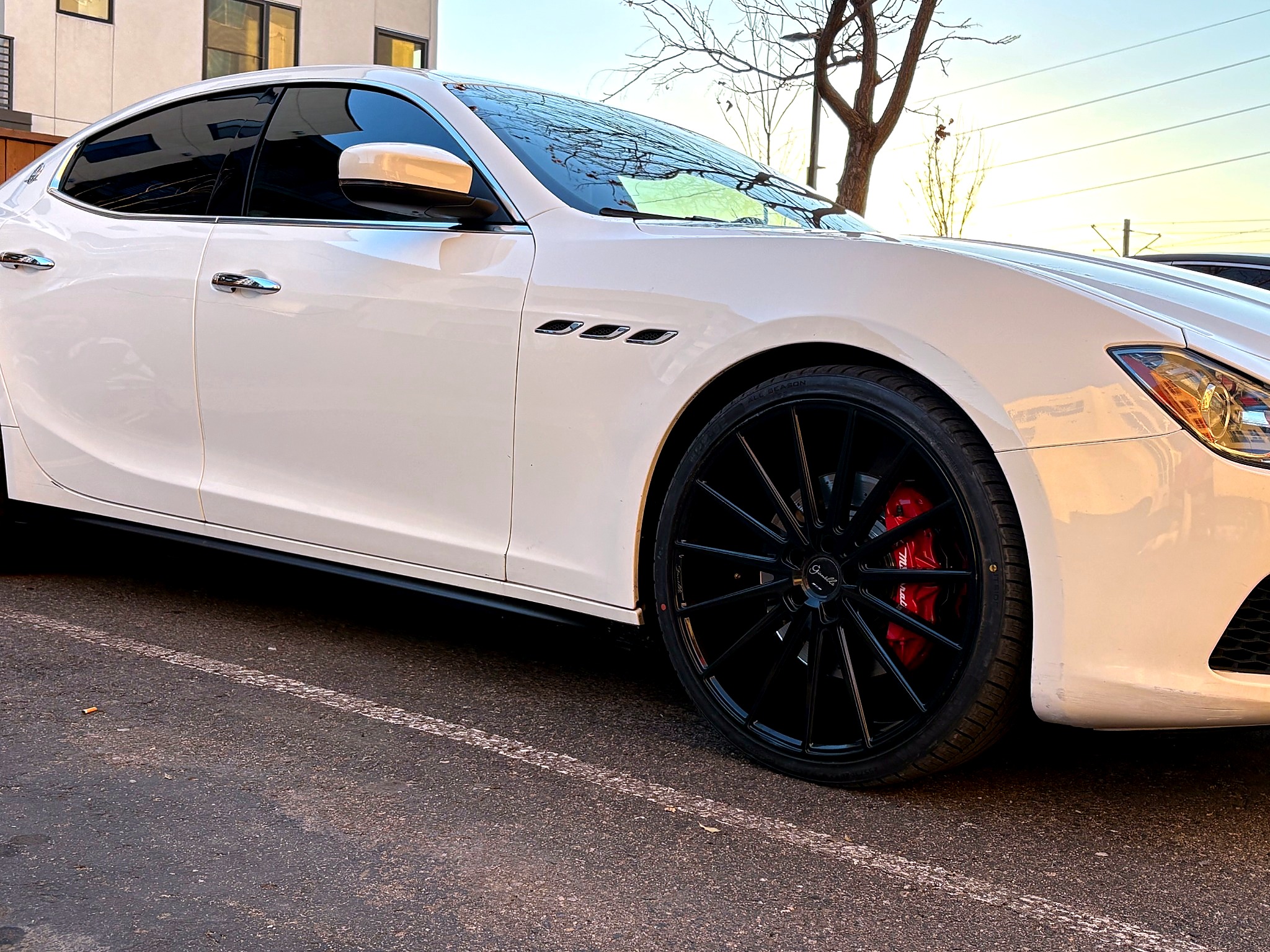 Maserati wheel and brake detail on white luxury sedan