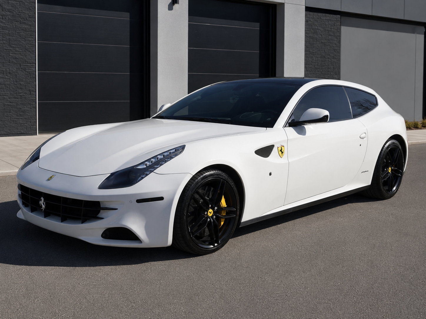 White Ferrari FF three-quarter view with black wheels and yellow calipers